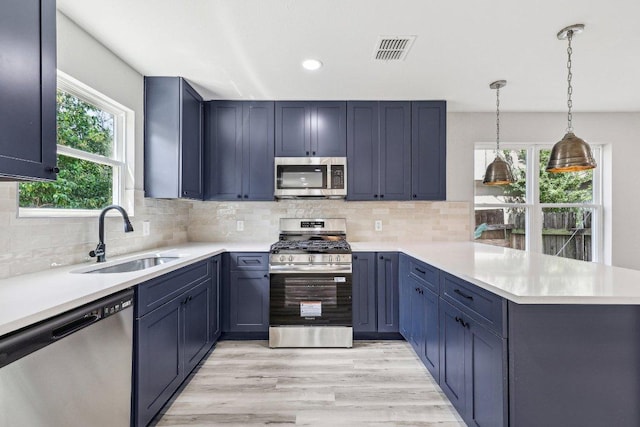 8804 Ravello Pass, Austin, TX 78749 - kitchen featuring stainless steel appliances, a sink, a peninsula, light countertops, and recessed lighting