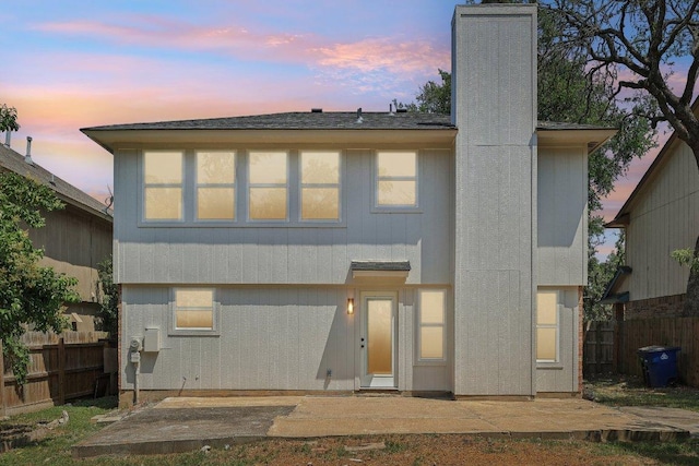 8804 Ravello Pass, Austin, TX 78749 - back of house at dusk featuring a chimney and a patio area