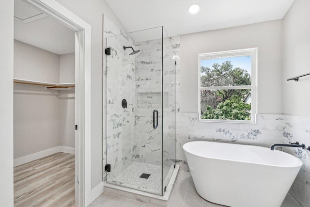 8804 Ravello Pass, Austin, TX 78749 - bathroom featuring a freestanding tub, a shower stall, a spacious closet, tile walls, and recessed lighting