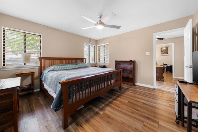 6807 Bill Hughes Rd, Austin, TX 78745 - bedroom with light wood finished floors, multiple windows, baseboards, and ceiling fan