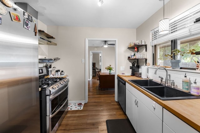 6807 Bill Hughes Rd, Austin, TX 78745 - kitchen with stainless steel appliances, a sink, wood counters, dark wood-type flooring, and white cabinets