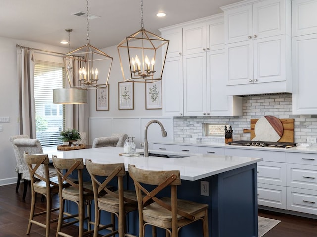 108 Brantley Lake Ln, Georgetown, TX 78628 - kitchen with stainless steel gas stovetop, a sink, a chandelier, decorative backsplash, and white cabinets