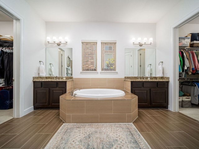108 Brantley Lake Ln, Georgetown, TX 78628 - full bathroom featuring wood tiled floors, two vanities, and a chandelier