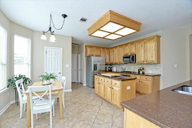 2012 Wood Glen Dr, Round Rock, TX 78681 - kitchen featuring stainless steel appliances, backsplash, light tile patterned floors, a kitchen island, and light brown cabinetry