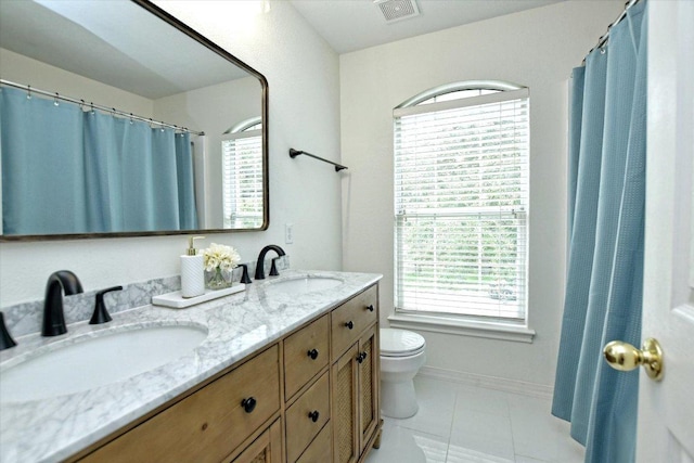 2012 Wood Glen Dr, Round Rock, TX 78681 - full bathroom featuring toilet, double vanity, plenty of natural light, and tile patterned floors