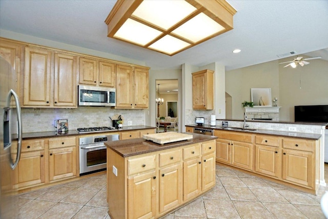 2012 Wood Glen Dr, Round Rock, TX 78681 - kitchen with appliances with stainless steel finishes, a sink, light tile patterned flooring, a kitchen island, and recessed lighting