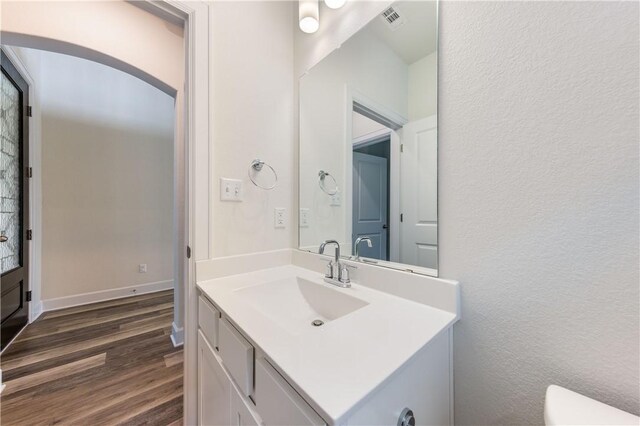 748 Hazy Hills Loop, Dripping Springs, TX 78620 - half bath featuring vanity, toilet, wood finished floors, and a textured wall