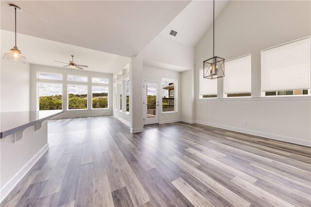 748 Hazy Hills Loop, Dripping Springs, TX 78620 - unfurnished living room featuring healthy amount of natural light, ceiling fan, wood finished floors, baseboards, and high vaulted ceiling