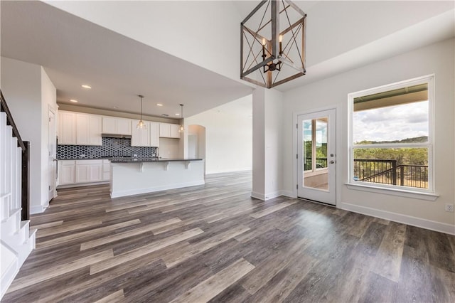 748 Hazy Hills Loop, Dripping Springs, TX 78620 - kitchen with dark countertops, a chandelier, open floor plan, white cabinets, and dark wood-style floors