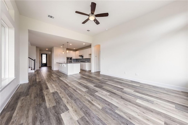 748 Hazy Hills Loop, Dripping Springs, TX 78620 - unfurnished living room featuring wood finished floors, ceiling fan, stairs, baseboards, and recessed lighting