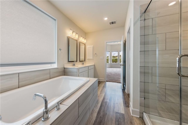 748 Hazy Hills Loop, Dripping Springs, TX 78620 - full bath featuring double vanity, a stall shower, a garden tub, wood finished floors, and baseboards