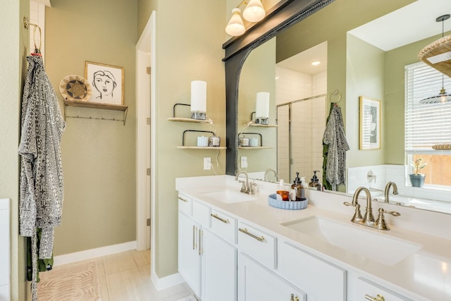 111 Blackwell Ln, Kyle, TX 78640 - bathroom with healthy amount of natural light, double vanity, a tile shower, and baseboards