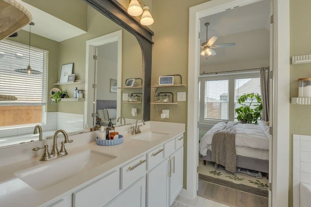 111 Blackwell Ln, Kyle, TX 78640 - full bathroom featuring connected bathroom, ceiling fan, double vanity, a tub, and wood finished floors