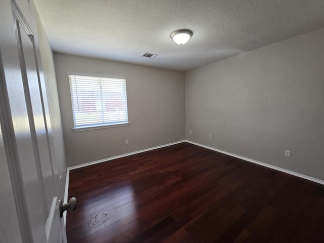 13820 Ceylon Tea Cir, Pflugerville, TX 78660 - spare room featuring dark wood-style flooring, baseboards, and a textured ceiling