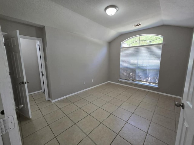 13820 Ceylon Tea Cir, Pflugerville, TX 78660 - empty room with vaulted ceiling, light tile patterned floors, a textured ceiling, and baseboards