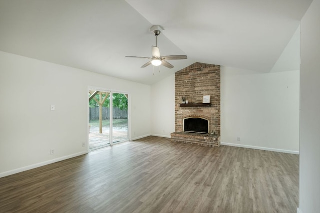 9001 Lodge Ct, Austin, TX 78758 - unfurnished living room featuring ceiling fan, wood finished floors, vaulted ceiling, a brick fireplace, and baseboards