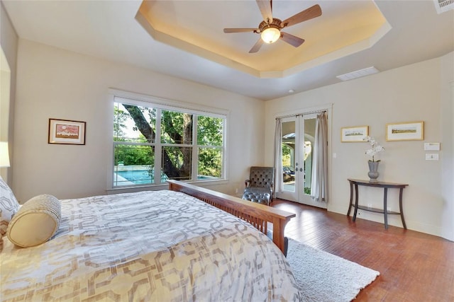 7116 Greenshores Dr, Austin, TX 78730 - bedroom featuring access to exterior, wood finished floors, a tray ceiling, baseboards, and a ceiling fan