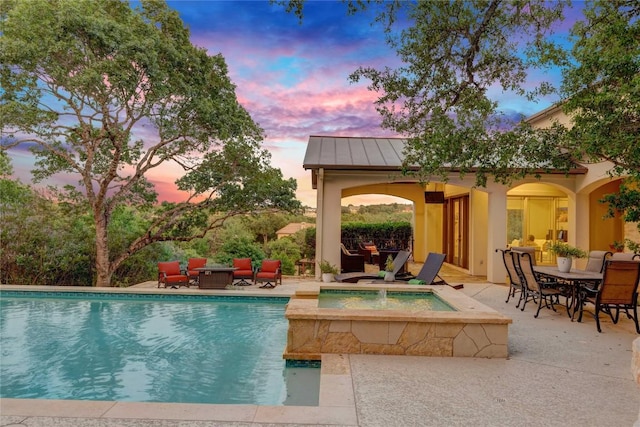 7116 Greenshores Dr, Austin, TX 78730 - pool at dusk with an outdoor pool, a patio area, an in-ground hot tub, outdoor lounge area, and outdoor dining area