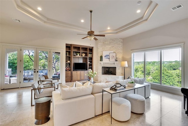 7116 Greenshores Dr, Austin, TX 78730 - living room with a tray ceiling, a ceiling fan, recessed lighting, a fireplace, and light tile patterned flooring
