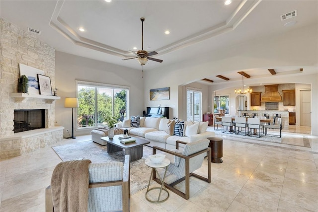 7116 Greenshores Dr, Austin, TX 78730 - living room featuring a tray ceiling, a ceiling fan, recessed lighting, a stone fireplace, and plenty of natural light