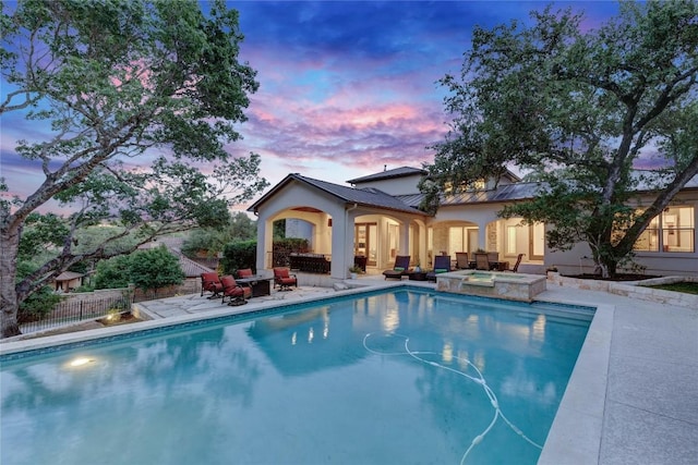 7116 Greenshores Dr, Austin, TX 78730 - pool at dusk featuring a patio area, a pool with connected hot tub, and an outdoor living space
