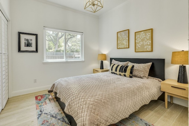 101 Peterson Ct, Austin, TX 78734 - bedroom featuring ornamental molding, a chandelier, light wood-type flooring, and baseboards