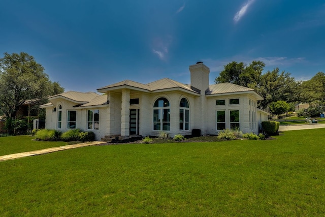 101 Peterson Ct, Austin, TX 78734 - rear view of property featuring brick siding, a yard, a chimney, and a metal roof