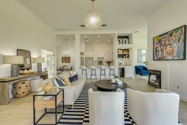 101 Peterson Ct, Austin, TX 78734 - living area with crown molding, beverage cooler, a chandelier, and light wood-type flooring