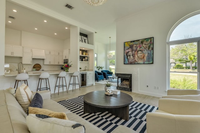 101 Peterson Ct, Austin, TX 78734 - living room with beverage cooler, plenty of natural light, light wood-type flooring, recessed lighting, and a towering ceiling