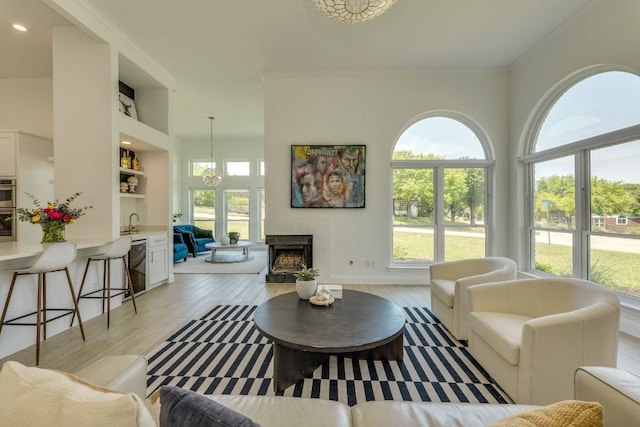 101 Peterson Ct, Austin, TX 78734 - living room with a chandelier, light wood finished floors, a fireplace, ornamental molding, and recessed lighting
