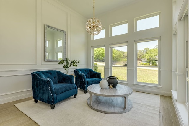 101 Peterson Ct, Austin, TX 78734 - living area featuring a decorative wall, a chandelier, wood finished floors, crown molding, and a high ceiling