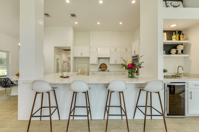 101 Peterson Ct, Austin, TX 78734 - kitchen featuring beverage cooler, open shelves, tasteful backsplash, white cabinets, and recessed lighting