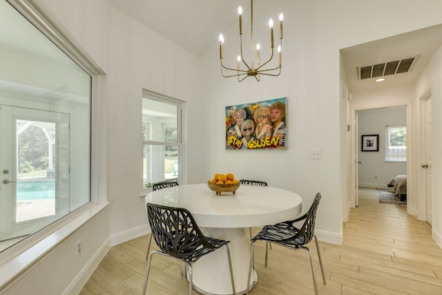 101 Peterson Ct, Austin, TX 78734 - dining area featuring light wood finished floors, a chandelier, baseboards, and a high ceiling
