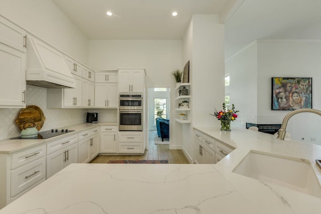 101 Peterson Ct, Austin, TX 78734 - kitchen with a sink, double oven, light stone counters, backsplash, and white cabinetry