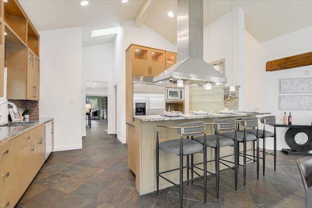 4715 Highland Ter, Austin, TX 78731 - kitchen with island range hood, built in appliances, a peninsula, decorative backsplash, and dark stone finish flooring