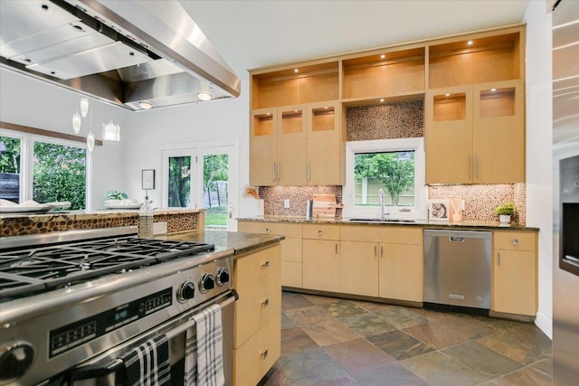4715 Highland Ter, Austin, TX 78731 - kitchen with stainless steel appliances, wall chimney range hood, decorative backsplash, and plenty of natural light
