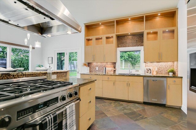 4715 Highland Ter, Austin, TX 78731 - kitchen with stainless steel appliances, wall chimney range hood, decorative backsplash, and plenty of natural light