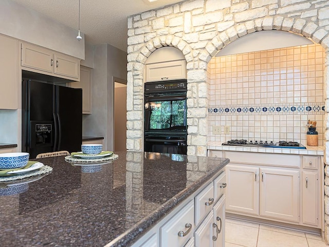 1400 Pearl Cv, Round Rock, TX 78681 - kitchen with black appliances, light tile patterned floors, and a textured ceiling