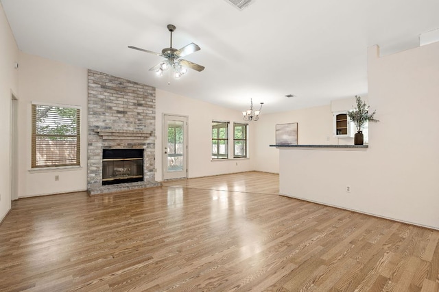 8507 Tad Park Cv, Round Rock, TX 78681 - unfurnished living room featuring a ceiling fan, light wood-style flooring, a fireplace, a chandelier, and lofted ceiling