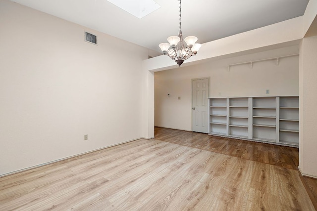 8507 Tad Park Cv, Round Rock, TX 78681 - unfurnished room featuring wood finished floors and a chandelier