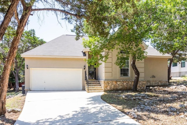 10 Lakewood Cir, Wimberley, TX 78676 - view of front of property with an attached garage, concrete driveway, stone siding, and stucco siding
