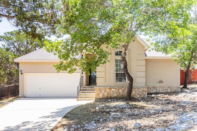 10 Lakewood Cir, Wimberley, TX 78676 - view of front of house with an attached garage, driveway, stone siding, stucco siding, and a shingled roof