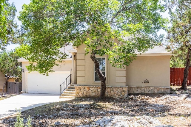 10 Lakewood Cir, Wimberley, TX 78676 - obstructed view of property featuring driveway, stucco siding, stone siding, and a garage
