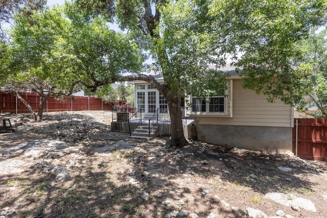 10 Lakewood Cir, Wimberley, TX 78676 - rear view of house with a wooden deck and a fenced backyard
