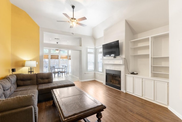 10 Lakewood Cir, Wimberley, TX 78676 - living area featuring ceiling fan, baseboards, wood finished floors, a tiled fireplace, and lofted ceiling