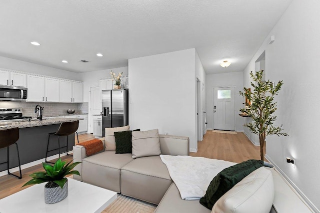 114 Ashford Way, Georgetown, TX 78626 - living room with light wood-style floors and recessed lighting