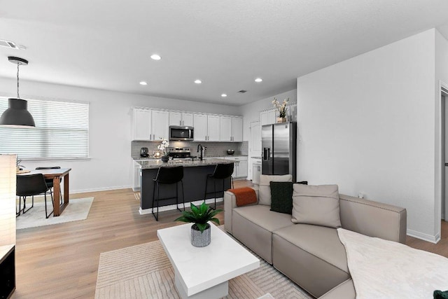 114 Ashford Way, Georgetown, TX 78626 - living area featuring baseboards, light wood finished floors, and recessed lighting