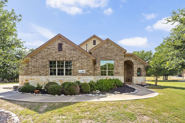 142 Abamillo Dr, Bastrop, TX 78602 - view of front of house featuring a front lawn, stone siding, and brick siding