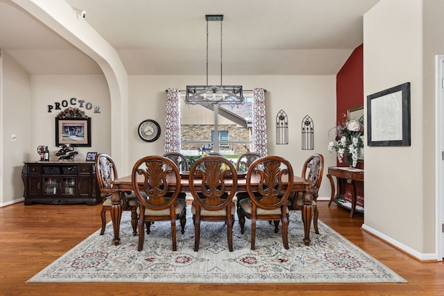 142 Abamillo Dr, Bastrop, TX 78602 - dining room featuring wood finished floors, arched walkways, and baseboards