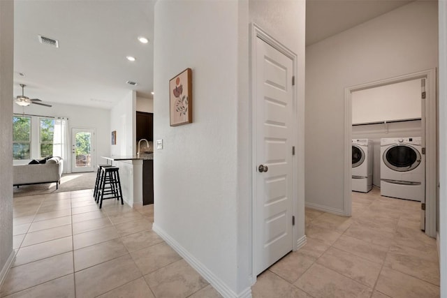 13002 Stanford Dr Unit 40, Austin, TX 78748 - corridor with washer and clothes dryer, light tile patterned floors, baseboards, recessed lighting, and a sink